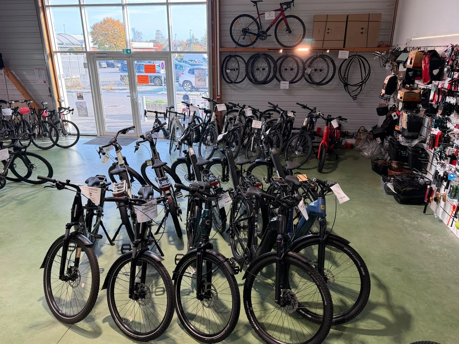 Vélos électriques, roues et entrée du magasin de Janzé